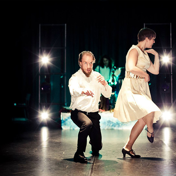Two dancers and a drummer performing